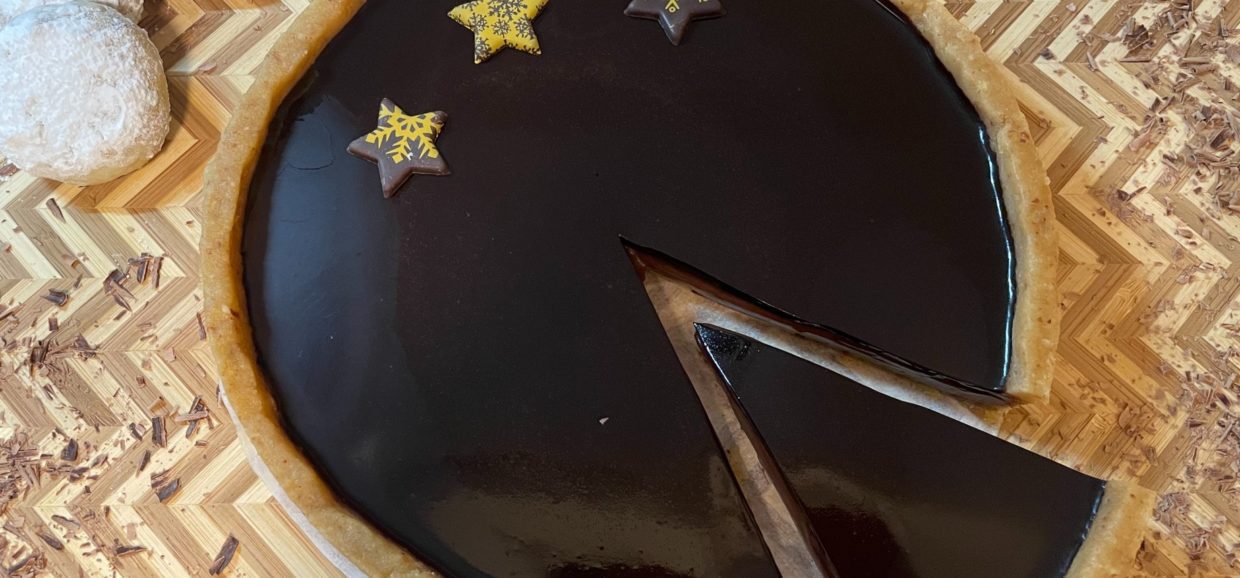 Συνταγή για μοναδική τάρτα σοκολάτας. Αν σας περίσσεψαν κουραμπιέδες δοκιμάστε αυτήν την υπέροχη τάρτα με βάση από κουραμπιέδες, γκανάς σοκολάτας και υπέροχο γυαλιστερό γλάσο.