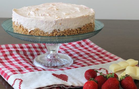 Συνταγή για υπέροχο Cheesecake φράουλας με λευκή σοκολάτα. Εύκολη βάση μπισκότου και δροσιστική κρέμα πλούσια σε γεύση και υφή. 