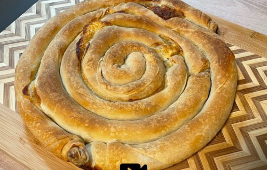 Συνταγή για στριφτή τυρόπιτα με χειροποίητο τραγανό φύλλο και υπέροχη γέμιση με φέτα, κίτρινο τυρί και γιαούρτι.