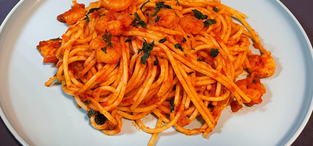 Γαριδομακαρονάδα αγαπημένη με κόκκινη σάλτσα, μυρωδικά και φυσικά σπαγγέτι βρασμένα αλ ντέντε. Μια γρήγορη και εύκολη συνταγή.