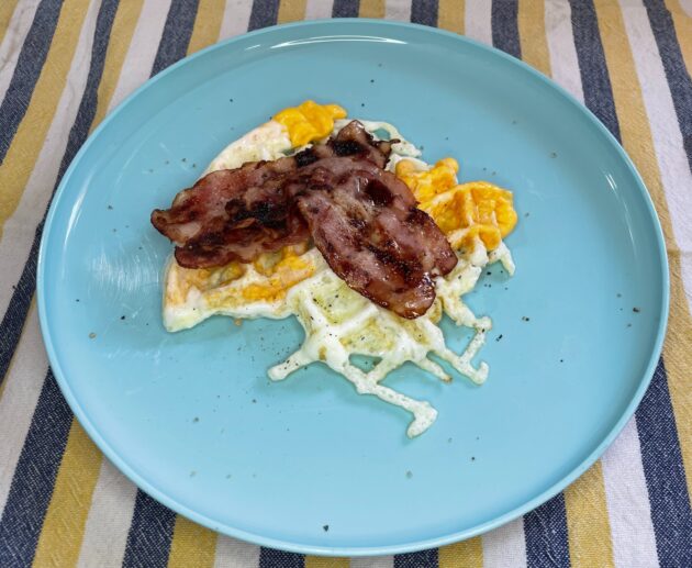 Αυγά με μπέικον στη βαφλιέρα. Ο συνδυασμός τα λέει όλα από μόνος του. Σερβίρουμε με ελαιόλαδο και πιπέρι.