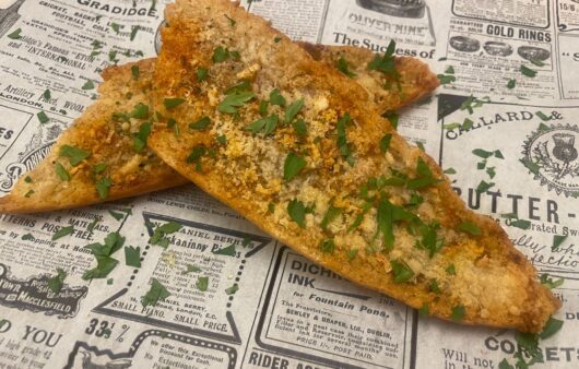 Αυθεντικό σκορδόψωμο με παρμεζάνα και βούτυρο. Τραγανή μπαγκέτα φούρνου, γεμάτη άρωμα σκόρδου – ιδανικό συνοδευτικό για κάθε γεύμα.