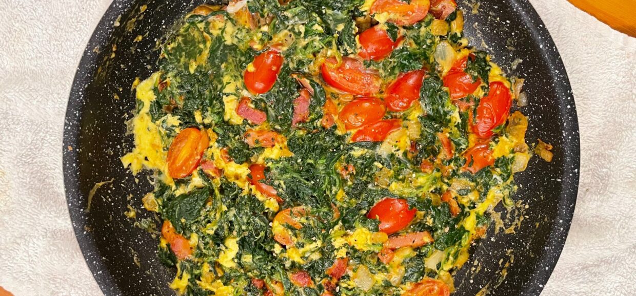 Εύκολη και γρήγορη ομελέτα με σπανάκι, μπέικον, κρεμμύδι, τοματίνια και παρμεζάνα. Ιδανική για θρεπτικό πρωινό ή ελαφρύ γεύμα.