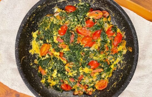 Εύκολη και γρήγορη ομελέτα με σπανάκι, μπέικον, κρεμμύδι, τοματίνια και παρμεζάνα. Ιδανική για θρεπτικό πρωινό ή ελαφρύ γεύμα.