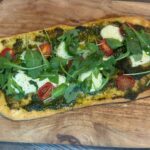 Φτιάξε πανεύκολο flatbread με πέστο, μοτσαρέλα, ντομάτα και ρόκα σε λίγα λεπτά. Τραγανή βάση, πλούσια γεύση.