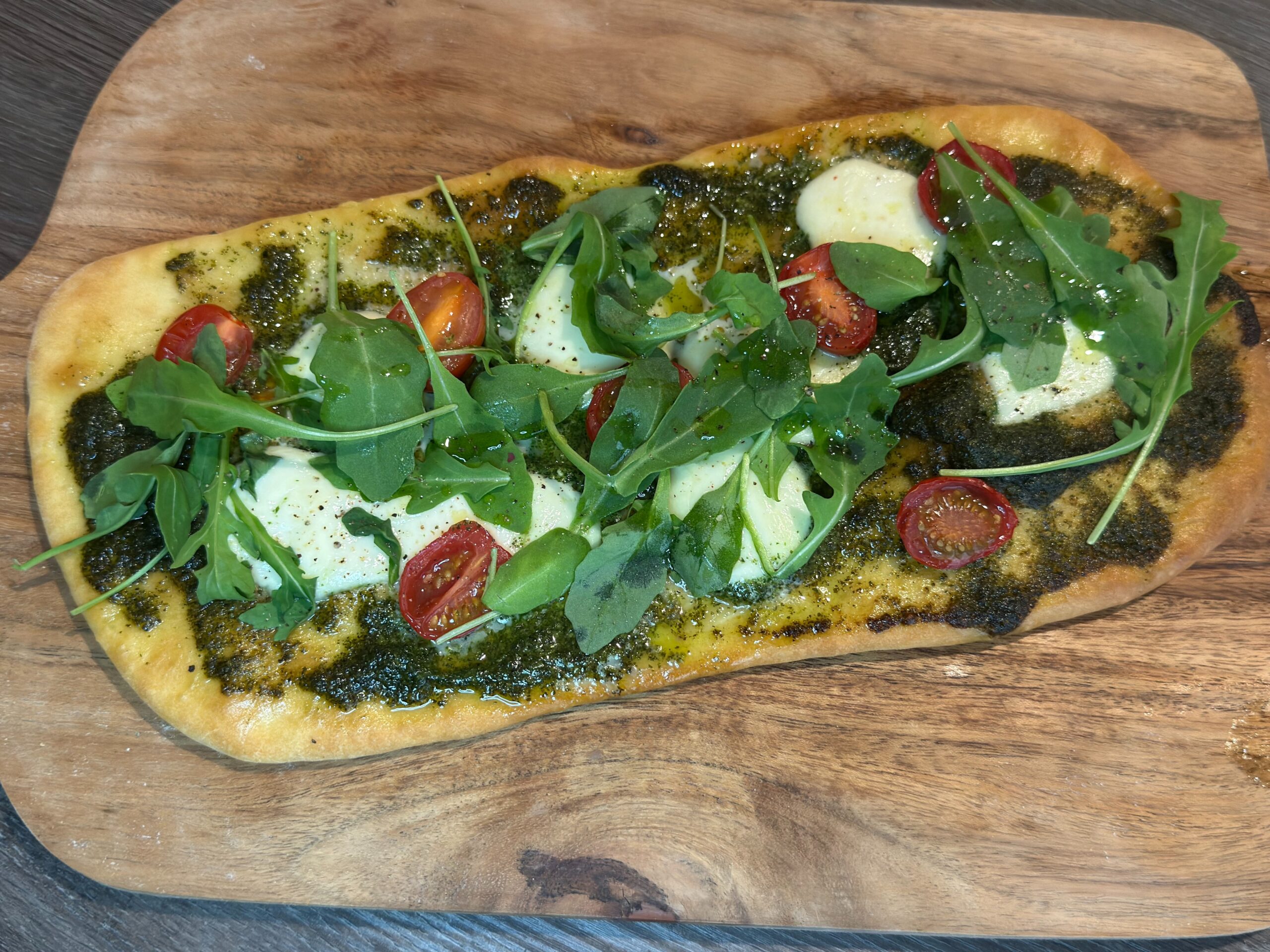 Φτιάξε πανεύκολο flatbread με πέστο, μοτσαρέλα, ντομάτα και ρόκα σε λίγα λεπτά. Τραγανή βάση, πλούσια γεύση.